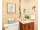 Charming bathroom showcasing a vanity with a plant, floral wallpaper and a framed picture at 4424 Robinson St, Acworth, GA 30101