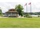 Picturesque park with a gazebo, American and state flags, picnic tables, and a serene lake backdrop at 4424 Robinson St, Acworth, GA 30101