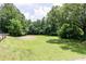 An expansive grassy lot, surrounded by lush, mature trees and greenery, creating a peaceful and natural setting at 4424 Robinson St, Acworth, GA 30101