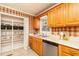 Well-organized kitchen with a double sink, wood cabinetry, and a pantry for storage at 4424 Robinson St, Acworth, GA 30101