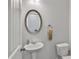 Neat half-bathroom with pedestal sink, oval mirror and neutral wall paint at 265 Valley Xing, Canton, GA 30114