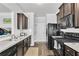 Well-equipped kitchen with dark wood cabinets, stainless appliances, and granite countertops at 265 Valley Xing, Canton, GA 30114