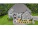 An aerial view of gray brick two-story house, showcases a well-manicured lawn and mature surrounding trees at 3206 Letha Woods Dr, Conyers, GA 30094