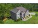 Aerial of gray brick two-story home surrounded by lush trees, and a large, beautifully maintained lawn at 3206 Letha Woods Dr, Conyers, GA 30094