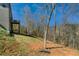 A wooded backyard behind a two-story gray brick home with a balcony overlooking the trees at 3206 Letha Woods Dr, Conyers, GA 30094