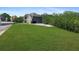 Gray brick home with a large front yard, driveway, manicured lawn, and lush surrounding foliage at 3206 Letha Woods Dr, Conyers, GA 30094