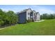 Side view of gray brick house showing the spacious lawn extending to the tree line at 3206 Letha Woods Dr, Conyers, GA 30094