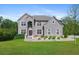 Imposing two-story gray brick home with well-manicured lawn, mature trees, and beautiful landscaping at 3206 Letha Woods Dr, Conyers, GA 30094