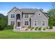 Imposing two-story gray brick home with well-manicured lawn, mature trees, and beautiful landscaping at 3206 Letha Woods Dr, Conyers, GA 30094