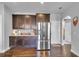 Stylish kitchen with stainless steel refrigerator, dark cabinets, and granite countertops at 3206 Letha Woods Dr, Conyers, GA 30094