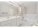 This bathroom features a dual sink vanity, built-in storage, and a soaking tub at 420 Eagle Tiff Dr, Sugar Hill, GA 30518