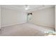 Spacious carpeted bedroom features a tray ceiling, ceiling fan, and a large window at 420 Eagle Tiff Dr, Sugar Hill, GA 30518