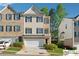 Charming multi-story townhouse featuring a two-car garage, well-manicured lawn, and mature landscaping at 420 Eagle Tiff Dr, Sugar Hill, GA 30518