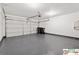 Spacious garage featuring epoxy floors, a large garage door and lots of room for storage at 420 Eagle Tiff Dr, Sugar Hill, GA 30518