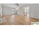 Bright living room featuring hardwood floors, a ceiling fan, fireplace, and stairs to the second floor at 420 Eagle Tiff Dr, Sugar Hill, GA 30518