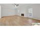 Bright living room featuring hardwood floors, fireplace, a ceiling fan and a doorway to the dining area at 420 Eagle Tiff Dr, Sugar Hill, GA 30518