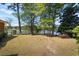 View of fenced yard with mature trees that has access to the lake and plenty of room for outdoor entertaining at 50 Silver Lake Dr, Mansfield, GA 30055