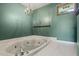 Bathroom features a green wall, chandelier, and a white-tiled whirlpool bathtub at 50 Silver Lake Dr, Mansfield, GA 30055
