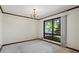 Empty bedroom with neutral carpet, wood trim, and large windows overlooking green trees at 50 Silver Lake Dr, Mansfield, GA 30055