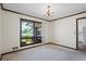 Empty bedroom with neutral carpet, wood trim, and large windows overlooking the lake at 50 Silver Lake Dr, Mansfield, GA 30055