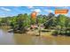 Beautiful waterfront home with mature trees and a charming red roof, offering serene lake views at 50 Silver Lake Dr, Mansfield, GA 30055