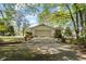 Detached garage with white walls and concrete driveway with lush trees at 50 Silver Lake Dr, Mansfield, GA 30055