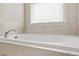 A relaxing bathtub with tile surround and window that gives natural light at 5895 Springbox Dr, Suwanee, GA 30024