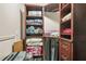 Image of a walk-in closet with shelving, packed with luggage and neatly folded towels at 5895 Springbox Dr, Suwanee, GA 30024