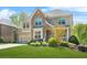 Beautiful two-story home featuring a brick and stone exterior, a well-maintained lawn, and a two-car garage at 5895 Springbox Dr, Suwanee, GA 30024