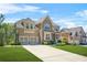 Elegant brick and stone home with a two-car garage and a lush green lawn at 5895 Springbox Dr, Suwanee, GA 30024