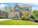 Beautiful two-story home featuring a brick and stone exterior, a well-maintained lawn, and a two-car garage at 5895 Springbox Dr, Suwanee, GA 30024