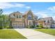 Elegant brick and stone home with a two-car garage and a lush green lawn at 5895 Springbox Dr, Suwanee, GA 30024