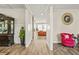 Elegant hallway featuring hardwood floors, decorative wall paneling, and an inviting view into the living room at 5895 Springbox Dr, Suwanee, GA 30024
