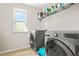 Convenient laundry room featuring modern washer and dryer with shelving for storage at 5895 Springbox Dr, Suwanee, GA 30024