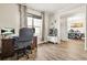 Inviting home office featuring a dark wood desk, a large window, and a view into the dining room at 5895 Springbox Dr, Suwanee, GA 30024