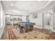 Bright recreation room features hardwood floors, a pool table, and access to the kitchen at 5895 Springbox Dr, Suwanee, GA 30024