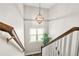 Staircase with wood handrail and decorative light fixture, enhancing the home's charm at 5895 Springbox Dr, Suwanee, GA 30024