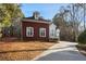 Side view of a brick home featuring white trim, a concrete driveway, and manicured landscaping at 175 Oak Manor, Fayetteville, GA 30214