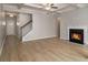 Open-concept living room with hardwood floors, a fireplace, and stairs to the second level at 2721 Kemp Sw Ct, Conyers, GA 30094