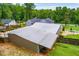 Aerial view of the metal roof on home with a well-maintained lawn and white picket fence at 84 Ledbetter Rd, Villa Rica, GA 30180
