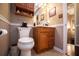 Bathroom features a vanity with storage, a mirror, a toilet, and wainscoting at 84 Ledbetter Rd, Villa Rica, GA 30180