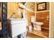 Functional utility bathroom features wood paneling, toilet, sink, and tiled floors at 84 Ledbetter Rd, Villa Rica, GA 30180