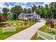 Charming home with manicured front yard, long driveway, lush greenery and white picket fence at 84 Ledbetter Rd, Villa Rica, GA 30180