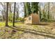 A storage shed sits amongst mature trees and lawn in the backyard at 2755 Austin Ln, Jonesboro, GA 30236