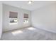 Well-lit bedroom featuring carpet flooring and two windows with tree views at 2959 Rambler Dr, Loganville, GA 30052