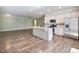 Open-concept kitchen with granite countertops, stainless steel appliances, and a large island, flowing into the living area at 2959 Rambler Dr, Loganville, GA 30052