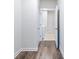 Bright hallway with a view of the laundry room, featuring wood-look flooring at 2959 Rambler Dr, Loganville, GA 30052