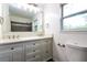 Bathroom featuring double sinks, a large mirror, and a window for natural light at 5170 2Nd St, Morrow, GA 30260