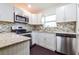 Kitchen with white cabinets, granite countertops, stainless steel appliances and mosaic tile backsplash at 5170 2Nd St, Morrow, GA 30260