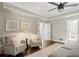 Bright bedroom features ceiling fan, hardwood floors, and cozy seating area at 9315 Prestwick Club Dr, Johns Creek, GA 30097